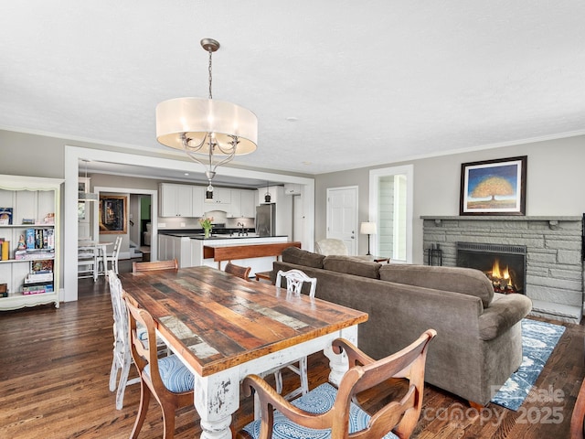 dining room featuring ornamental molding, a fireplace, and dark wood-style flooring