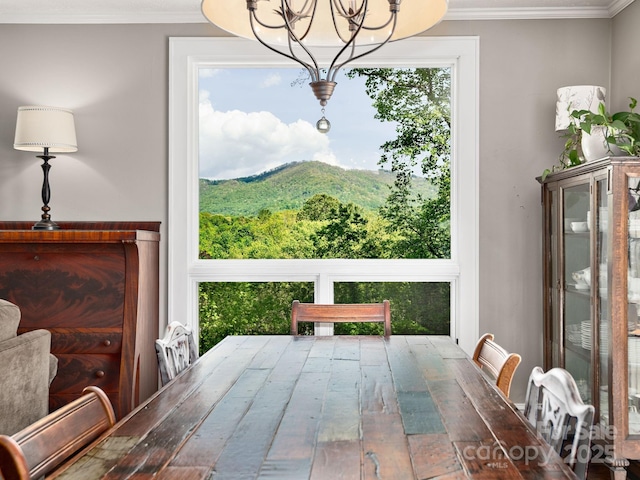 dining space featuring ornamental molding and a notable chandelier