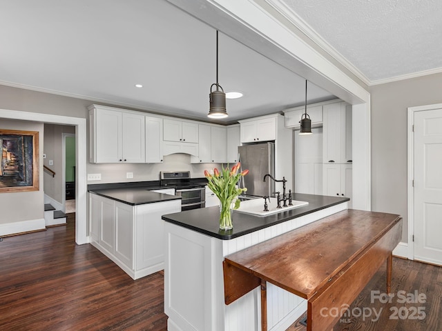 kitchen featuring white cabinetry, dark wood-style flooring, dark countertops, and stainless steel appliances