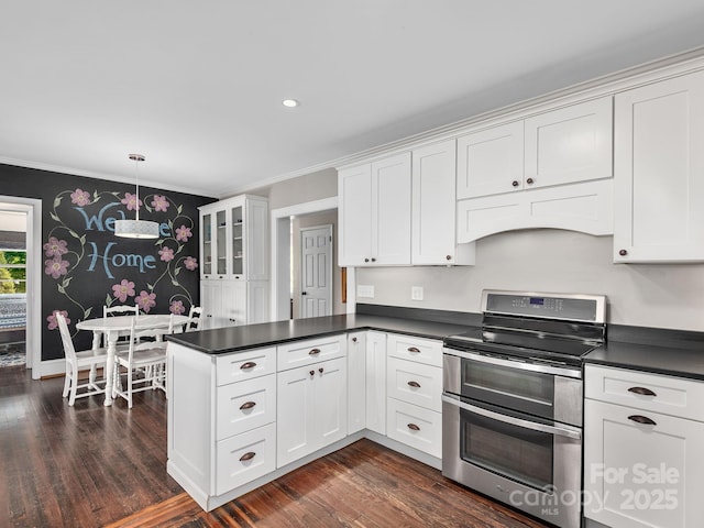 kitchen featuring crown molding, dark countertops, a peninsula, and range with two ovens