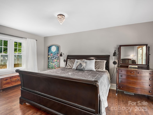 bedroom with baseboards and wood finished floors