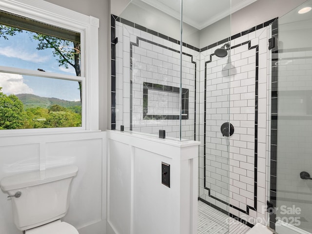 full bath with crown molding, toilet, a decorative wall, and a stall shower