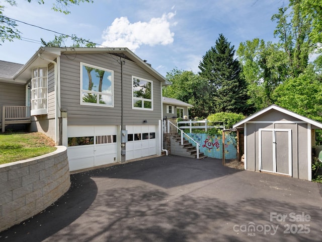 view of side of home featuring a garage, a shed, stairway, an outbuilding, and driveway