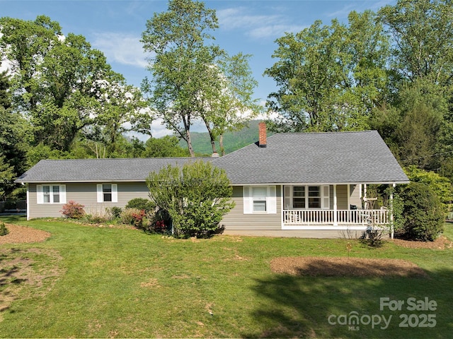 view of front of property featuring covered porch, roof with shingles, a chimney, and a front yard