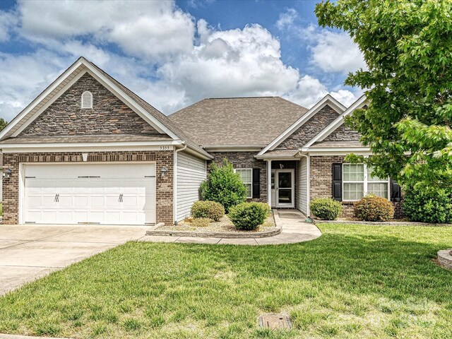 5355 Hackberry Ln SW, Concord, NC 28027 - view of front of property with stone siding, a garage, brick siding, a front yard, and driveway
