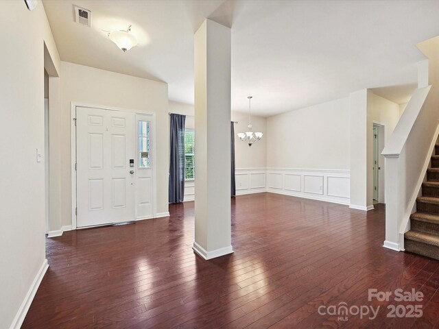 5355 Hackberry Ln SW, Concord, NC 28027 - foyer entrance featuring visible vents, wainscoting, stairway, a chandelier, and dark wood-type flooring