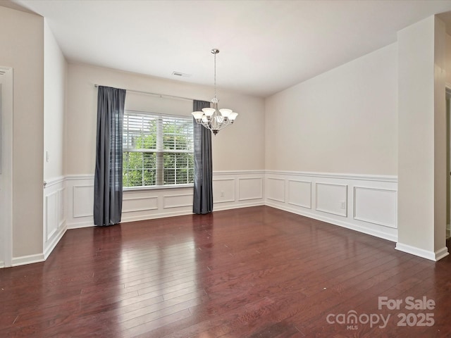 5355 Hackberry Ln SW, Concord, NC 28027 - empty room featuring a decorative wall, a chandelier, a wainscoted wall, hardwood / wood-style floors, and visible vents