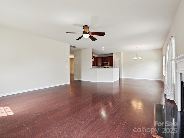 5355 Hackberry Ln SW, Concord, NC 28027 - unfurnished living room featuring visible vents, a fireplace, baseboards, ceiling fan with notable chandelier, and dark wood-style floors