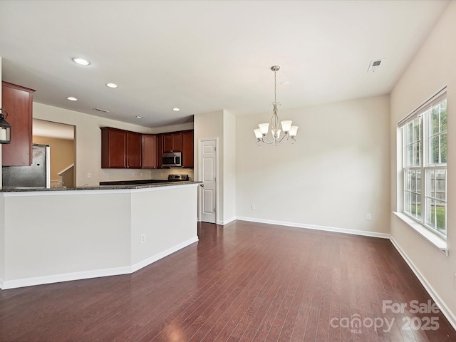 5355 Hackberry Ln SW, Concord, NC 28027 - kitchen featuring dark wood-style flooring, visible vents, appliances with stainless steel finishes, an inviting chandelier, and recessed lighting