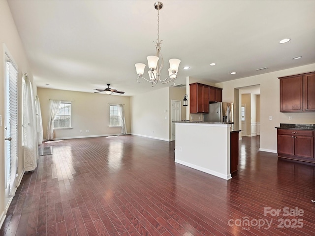 5355 Hackberry Ln SW, Concord, NC 28027 - kitchen featuring dark countertops, open floor plan, stainless steel refrigerator with ice dispenser, dark wood finished floors, and ceiling fan with notable chandelier
