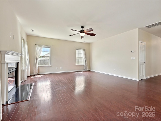 5355 Hackberry Ln SW, Concord, NC 28027 - unfurnished living room featuring dark wood-style flooring, ceiling fan, visible vents, and plenty of natural light