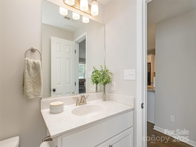 734 Enka Lake Rd, Candler, NC 28715 - bathroom with visible vents, wood finished floors, toilet, and vanity
