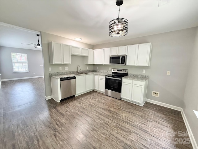 kitchen with stainless steel appliances, a sink, and baseboards