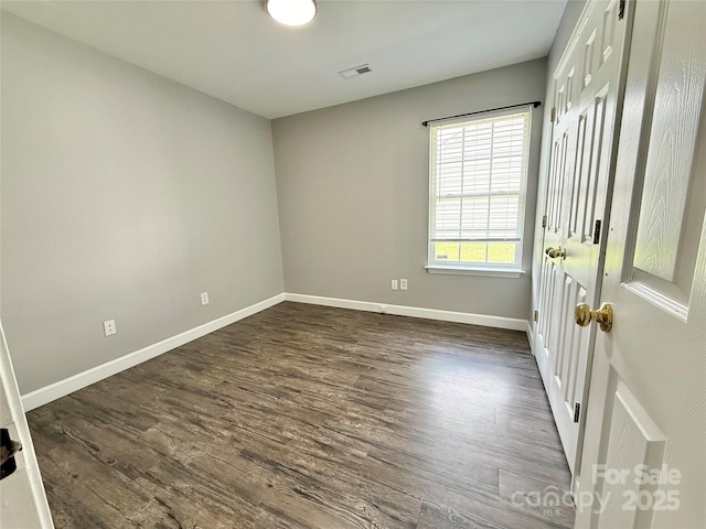 unfurnished bedroom featuring dark wood finished floors and baseboards