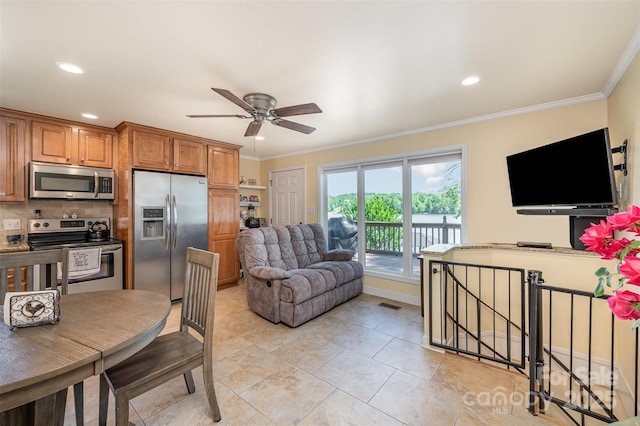 kitchen with brown cabinetry, a ceiling fan, crown molding, stainless steel appliances, and recessed lighting