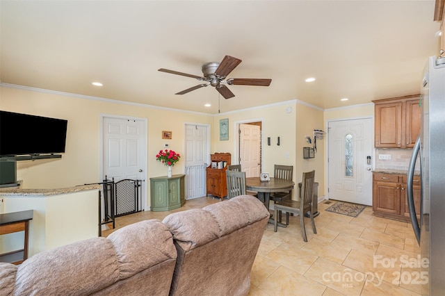 living room featuring baseboards, ceiling fan, ornamental molding, and recessed lighting