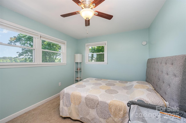carpeted bedroom with a ceiling fan and baseboards