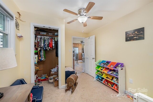 interior space featuring ceiling fan and light colored carpet