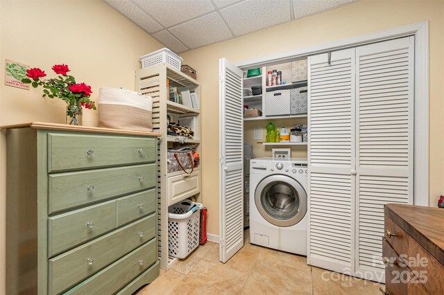 washroom with washer / clothes dryer, light tile patterned flooring, and laundry area