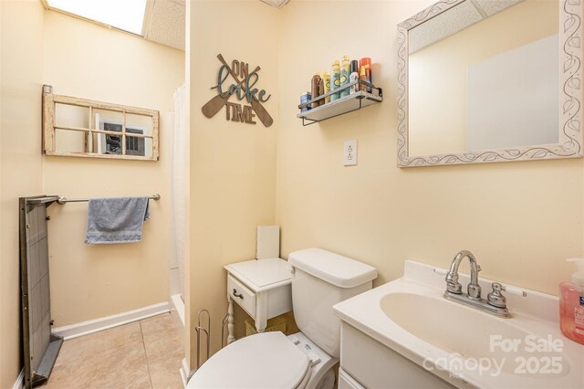 bathroom with tile patterned flooring, vanity, baseboards, toilet, and a shower with shower curtain