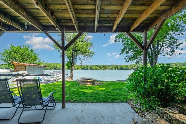 view of patio with a water view and a fire pit