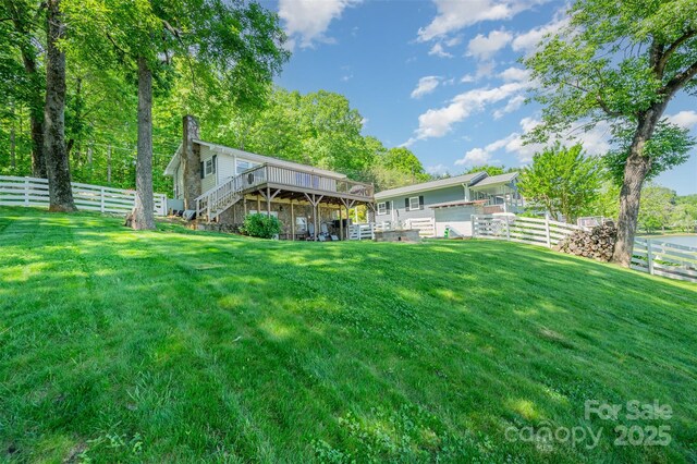 view of yard with a fenced backyard, a deck, and stairway