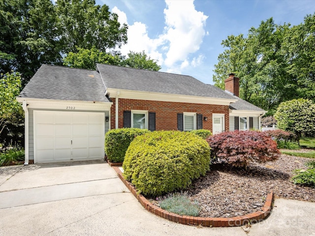 2502 Breuster Dr, Charlotte, NC 28210 - view of front of home with a shingled roof, brick siding, a garage, a chimney, and driveway