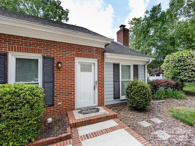 2502 Breuster Dr, Charlotte, NC 28210 - view of exterior entry with brick siding, a shingled roof, and a chimney