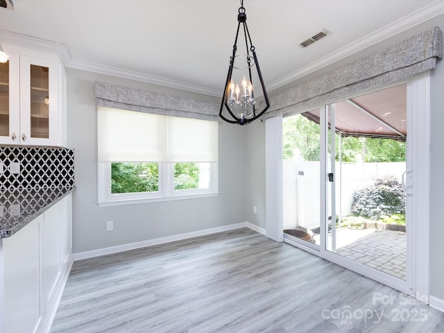 2502 Breuster Dr, Charlotte, NC 28210 - unfurnished dining area with ornamental molding, light wood-type flooring, a chandelier, and visible vents