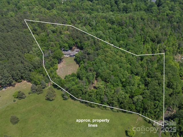 birds eye view of property featuring a wooded view