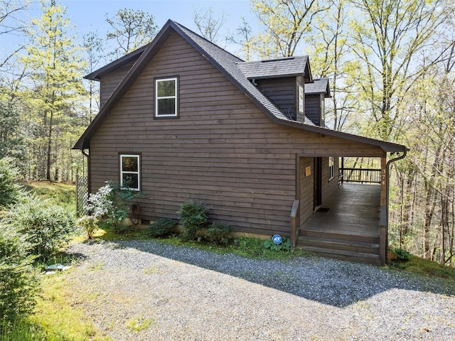 view of home's exterior featuring a shingled roof and covered porch