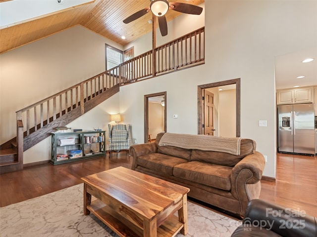 living area with a ceiling fan, wooden ceiling, high vaulted ceiling, stairs, and hardwood / wood-style floors