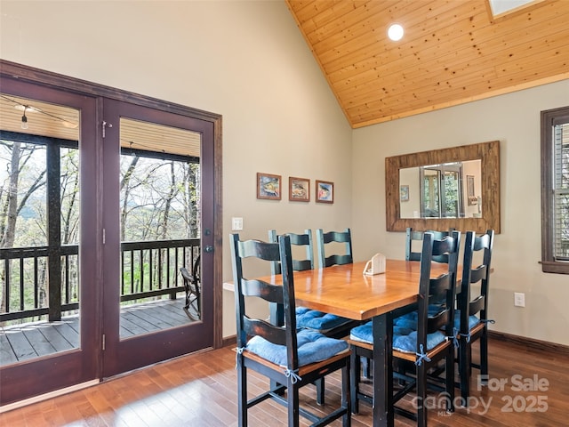 dining space with baseboards, wood finished floors, high vaulted ceiling, and wooden ceiling