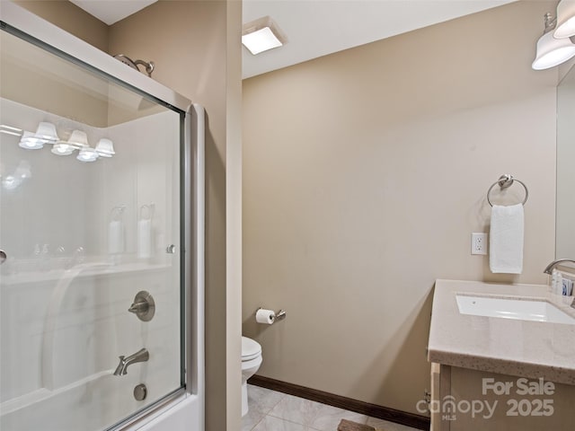bathroom featuring vanity, tile patterned flooring, toilet, baseboards, and enclosed tub / shower combo
