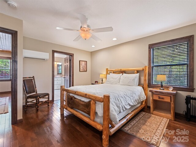 bedroom with radiator, baseboards, an AC wall unit, and hardwood / wood-style flooring