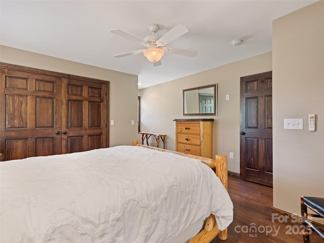 bedroom featuring dark wood-style flooring, a ceiling fan, and baseboards