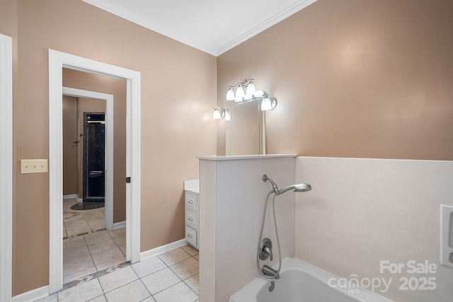 bathroom featuring vanity, ornamental molding, baseboards, tile patterned floors, and a tub to relax in