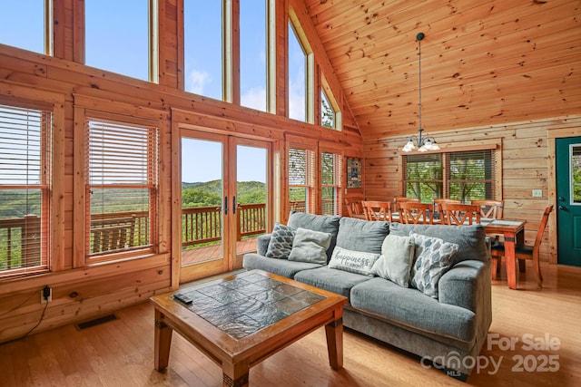 59 Valley Hts, Mars Hill, NC 28754 - living room featuring high vaulted ceiling, wood-type flooring, a chandelier, wooden walls, and a mountain view
