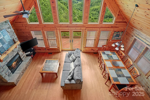 59 Valley Hts, Mars Hill, NC 28754 - living area featuring wood finished floors, a ceiling fan, high vaulted ceiling, a stone fireplace, and wood walls