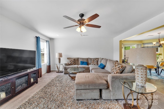 carpeted living area with visible vents, baseboards, and ceiling fan with notable chandelier