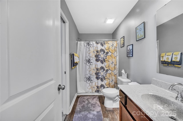 bathroom with vanity, wood finished floors, toilet, and a shower with curtain