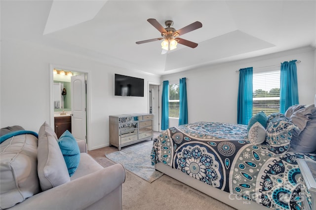 bedroom featuring ceiling fan, a sink, carpet floors, ensuite bathroom, and a tray ceiling