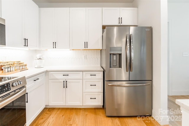 kitchen featuring decorative backsplash, light wood-type flooring, light countertops, white cabinets, and stainless steel appliances