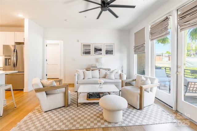 living area with light wood-style flooring and ceiling fan