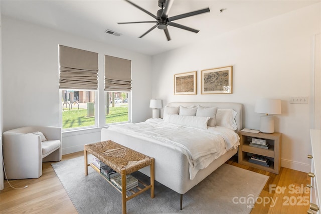 bedroom with visible vents, a ceiling fan, baseboards, and light wood-type flooring
