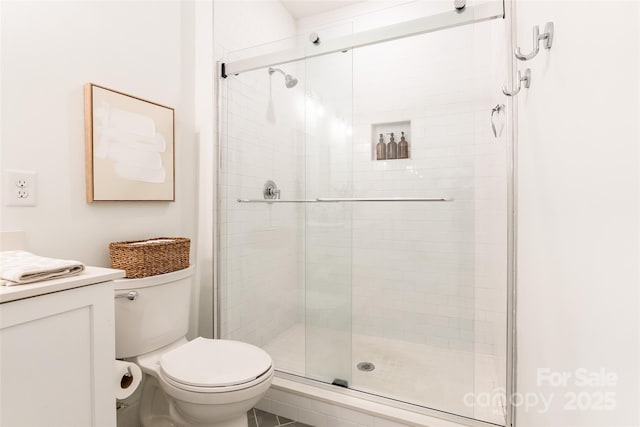 bathroom with vanity, a stall shower, and toilet