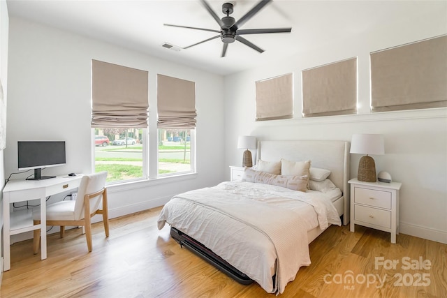 bedroom with light wood-style floors, baseboards, ceiling fan, and visible vents
