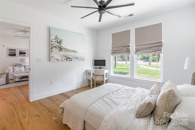 bedroom featuring a ceiling fan, baseboards, visible vents, and light wood finished floors
