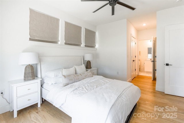 bedroom featuring light wood-style floors, a ceiling fan, and ensuite bath