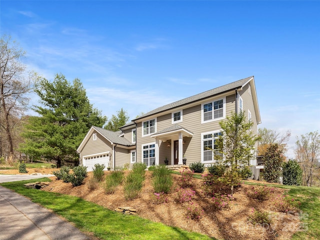 colonial-style house featuring an attached garage and driveway